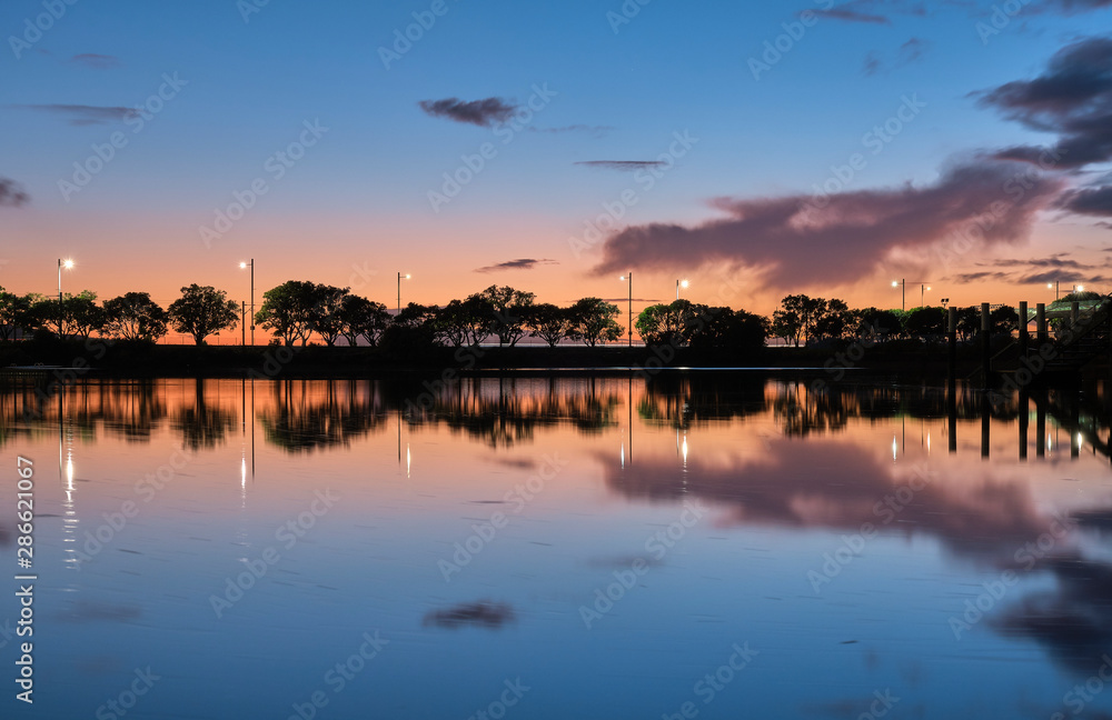 Obraz premium summer sunset on the lake with clouds reflection