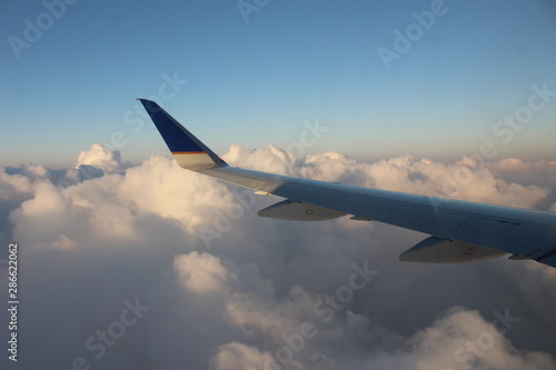 wing of an airplane flying above clouds