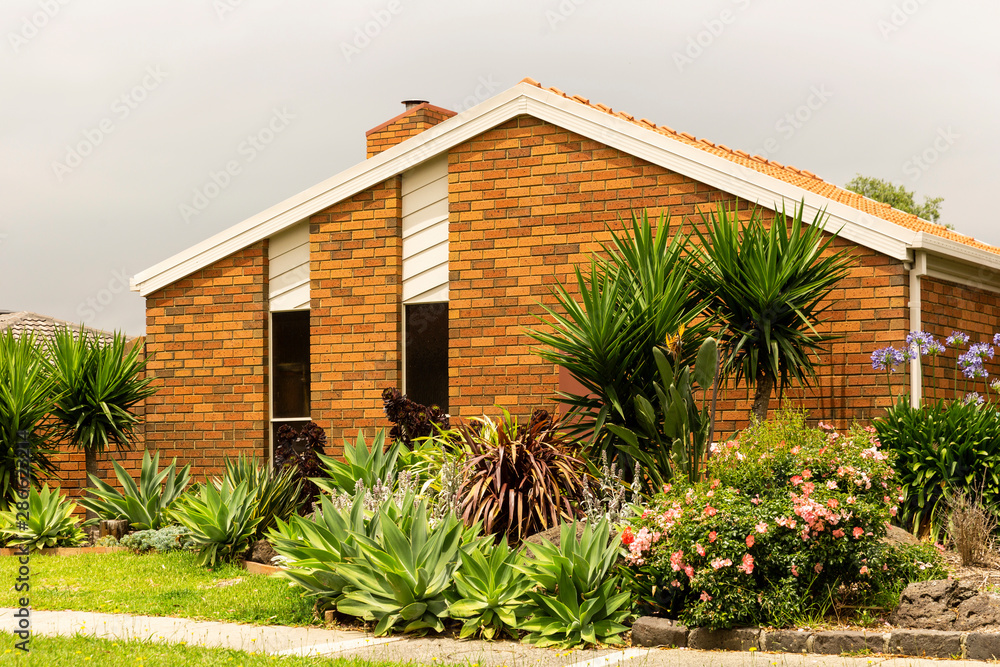 Fototapeta premium Tropical garden suburban home in quiet street.