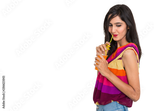 Good looking young girl drinking orange soft drink on isolated white background