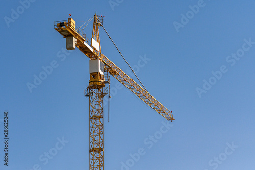 concrete construction yard building site yellow crane in front of blue sky background