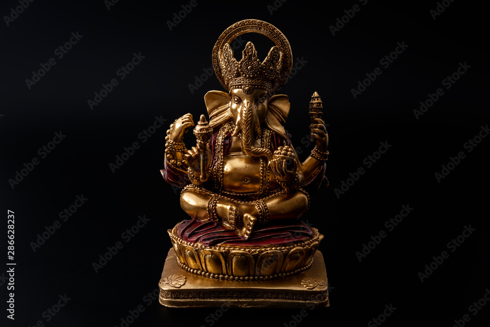 Happy Diwali, divine bless and spiritual harmony conceptual idea with Ganesh the hindu half elephant god of beginnings in meditation pose isolated on black background with clipping path cutout