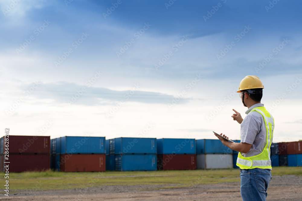 Male engineer, worker inspection checking on container by using tablet.