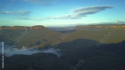 Wallpaper Mural The Three Sisters rocks formation at Blue Mountains with view of clouds covering the rainforest trees, Sydney Australia. Amazing aerial top bottom drone shot. Torontodigital.ca