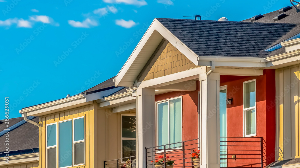 Panorama Exterior of townhomes with cream and red walls viewed against sky on a sunny day Panorama Exterior of townhomes with cream and red walls viewed against sky on a sunny day
