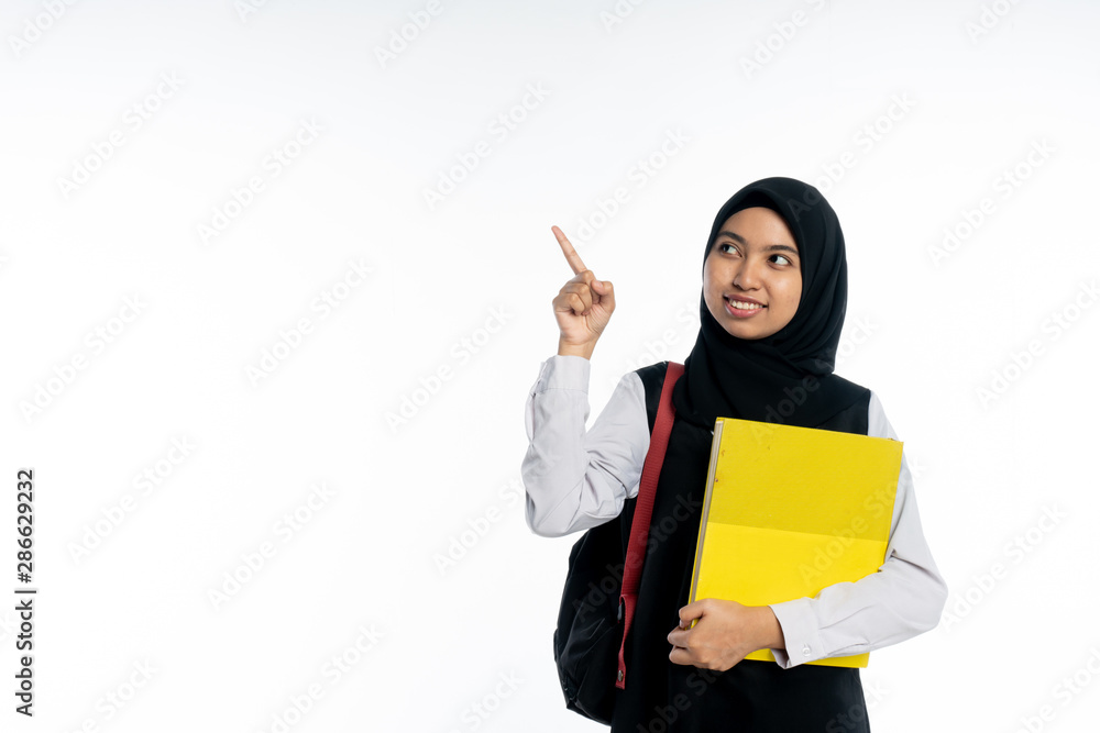 smiley asian student holding books pointing up with one finger got a good idea isolated on white background. smiley asian student holding books pointing up with one finger got a good idea isolated on white background.