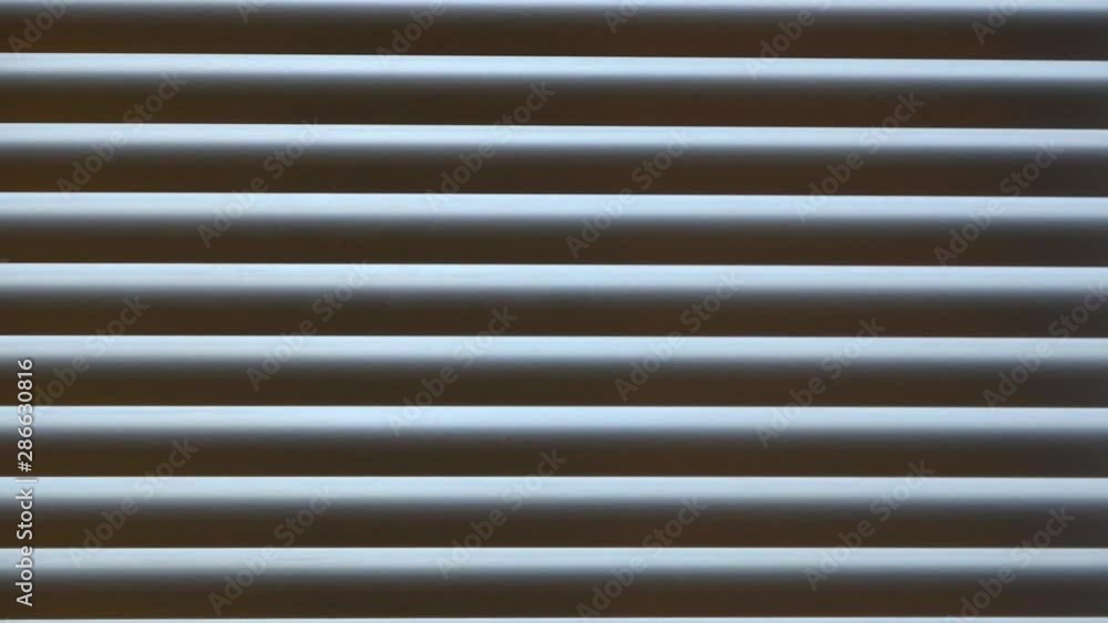 Curious man looking through Venetian window. Hand revealing white Venetian blinds Curious man looking through Venetian window. Hand revealing white Venetian blinds