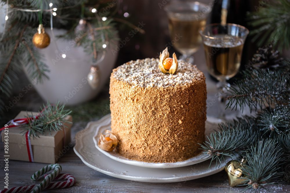 Homemade honey cake. Winter composition. New Year photo. Christmas decoration. Christmas decorations. Cake with sparklers. garland on a tree. Champagne in the glasses Homemade honey cake. Winter composition. New Year photo. Christmas decoration. Christmas decorations. Cake with sparklers. garland on a tree. Champagne in the glasses