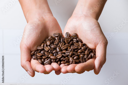 Woman's hands holding coffee beans