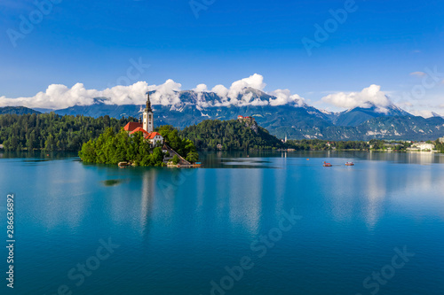 Bled, Slovenia - Lake Bled (Blejsko Jezero) with the Pilgrimage Church of the Assumption of Maria on a small island and Bled Castle and Julian Alps at backgroud at summer time with clear blue sky