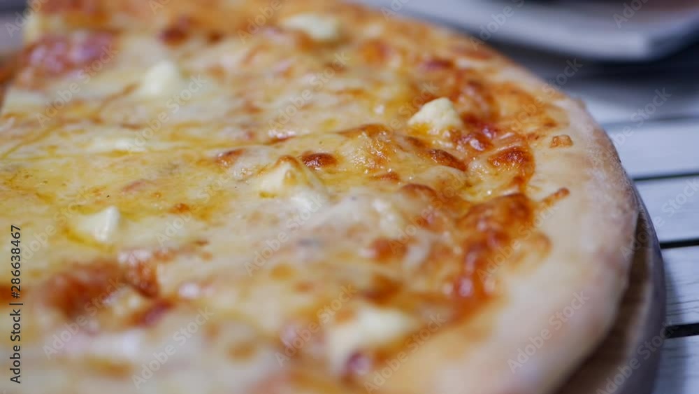 Closeup shot of pizza with melted cheese ready to eat. Delicious food for gluttony and enjoyment. Fast food eating concept. Slow motion Closeup shot of pizza with melted cheese ready to eat. Delicious food for gluttony and enjoyment. Fast food eating concept. Slow motion