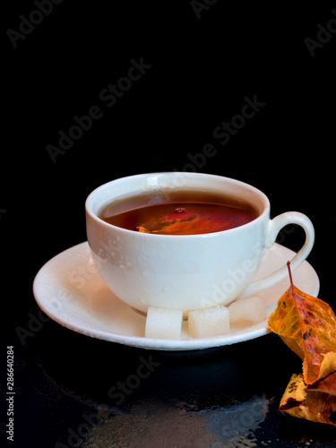 Autumn leaves with a white cup of tea