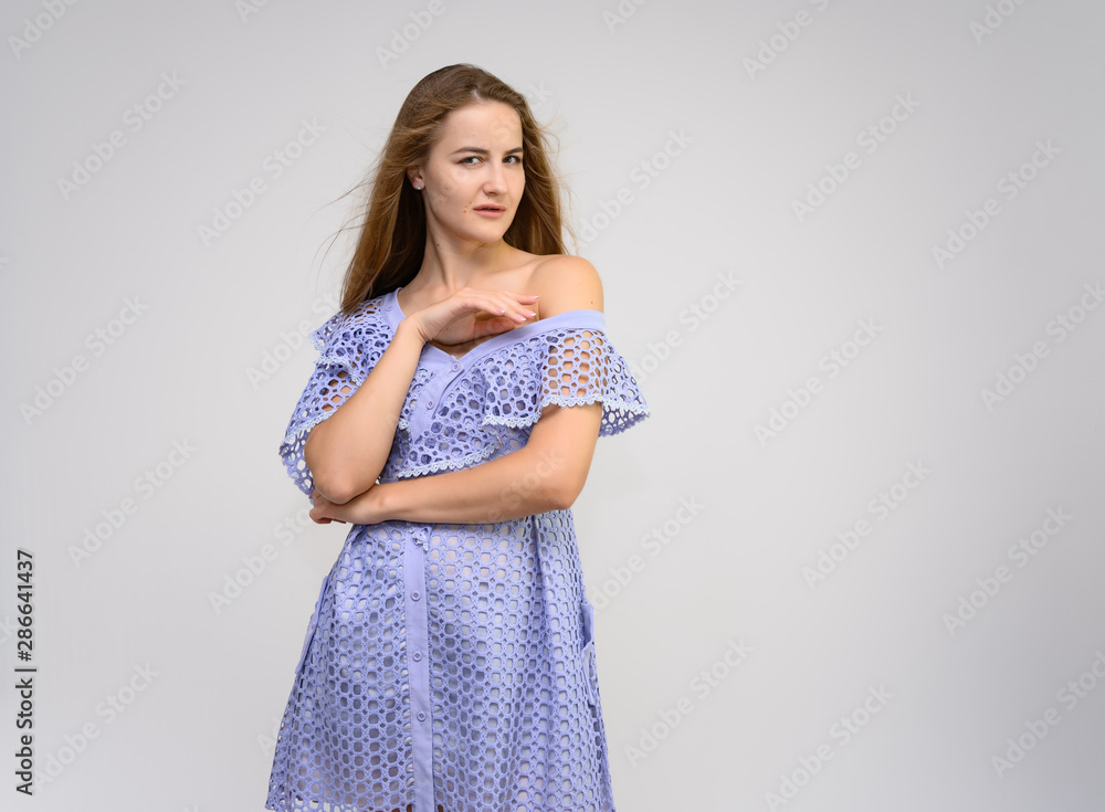 Studio portrait of a knee-length of a pretty girl student, brunette young woman with long beautiful hair in a dress on a white background. Smiling, talking, showing emotions Studio portrait of a knee-length of a pretty girl student, brunette young woman with long beautiful hair in a dress on a white background. Smiling, talking, showing emotions