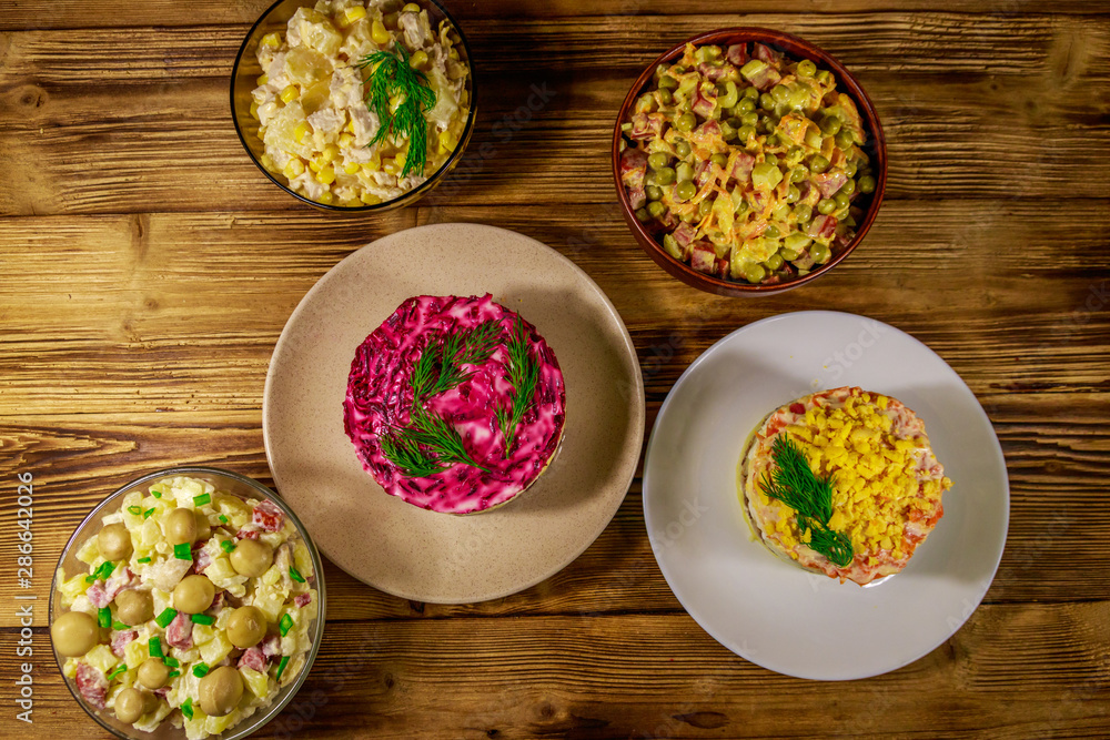 Set of festive mayonnaise salads on wooden table. Top view Set of festive mayonnaise salads on wooden table. Top view