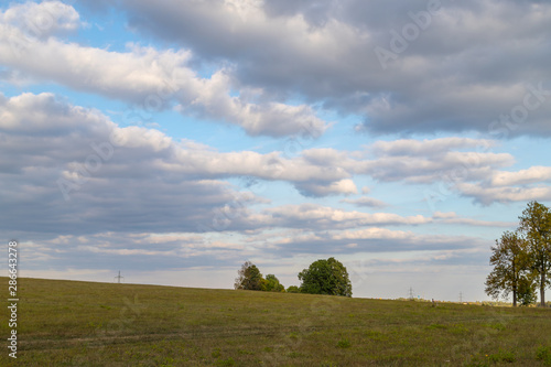 Beautiful sky with clouds over field and mountain © keleny