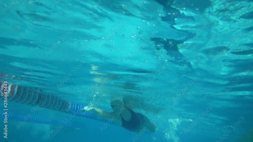 Amator swimmer with googles trains with effort and dedication to win the race by swimming in a freestyle pool. Amator swimmer with googles trains with effort and dedication to win the race by swimming in a freestyle pool.