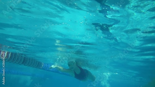 Amator swimmer with googles trains with effort and dedication to win the race by swimming in a freestyle pool. photo