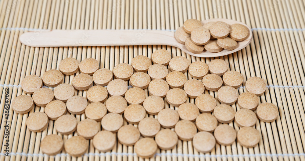 Alternative medicine tablets on a wooden spoon Alternative medicine tablets on a wooden spoon