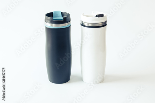 Isolated. Mockup. Black and white metal travel mugs with a place for your design. Close up.