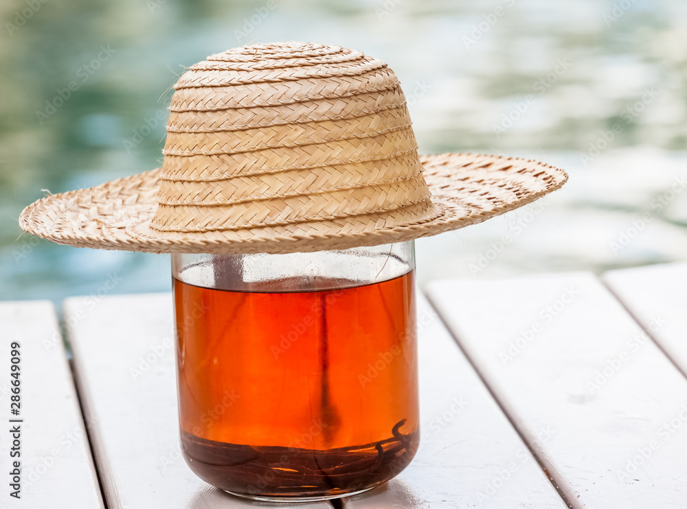 Chapeau de paille sur bocal de punch vanille Photos | Adobe Stock