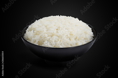 Jasmine cooked rice in a black bowl isolated on the black background. This has clipping path.