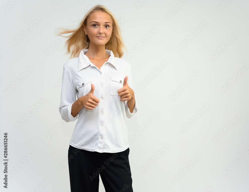 Studio portrait of a pretty blonde student girl, young woman in a white shirt on a white background. Talking, showing emotions. Studio portrait of a pretty blonde student girl, young woman in a white shirt on a white background. Talking, showing emotions.