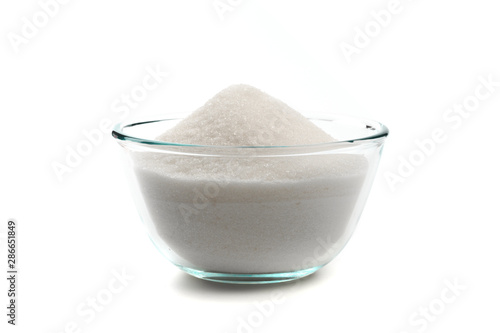 Sugar in glass bowl isolated on white background