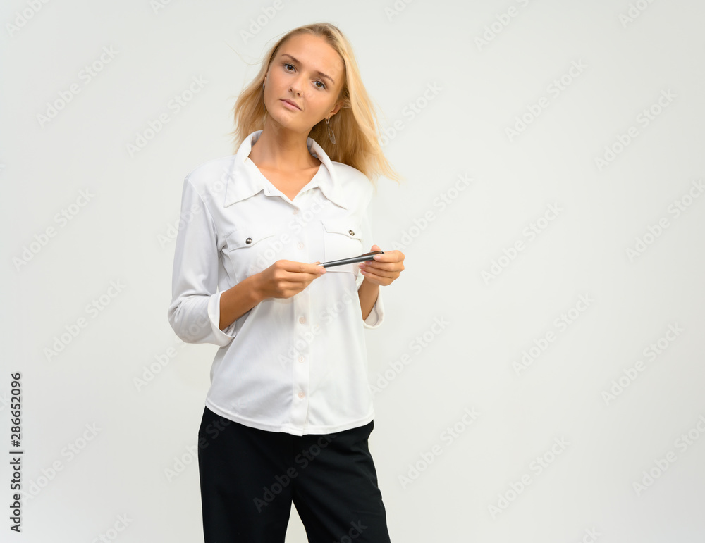 Studio portrait of a pretty blonde student girl, young woman in a white shirt on a white background. Talking, showing emotions. Studio portrait of a pretty blonde student girl, young woman in a white shirt on a white background. Talking, showing emotions.