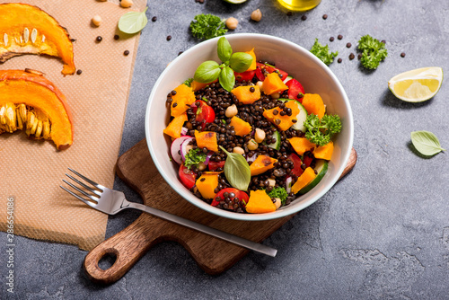 Healthy salad with roasted squash, chickpeas and black lentils, autumn food, vegan eating