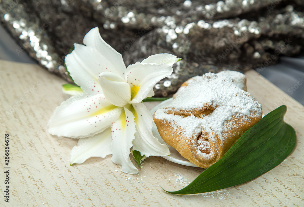 white lush beautiful lily with fresh pastries on a retro background white lush beautiful lily with fresh pastries on a retro background