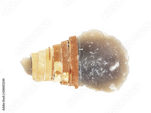 Replica of the primal stone knife or scrapper with leather stripe handle isolated on white background. Primitive stone dagger: tool of the prehistoric peoples.