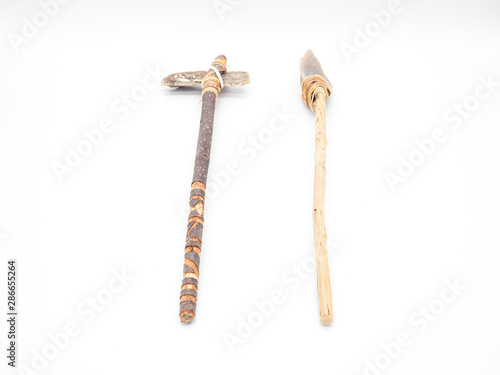 Replicas of the primal stone tools with wooden handles and leather strapping isolated on white background. Primitive stone axe and dagger or spear: weapons of the prehistoric peoples. Perspective view