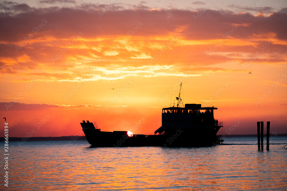 Fraser Island Ferry at sunset with orange sky, Fraser Island, Queensland, Australia Fraser Island Ferry at sunset with orange sky, Fraser Island, Queensland, Australia
