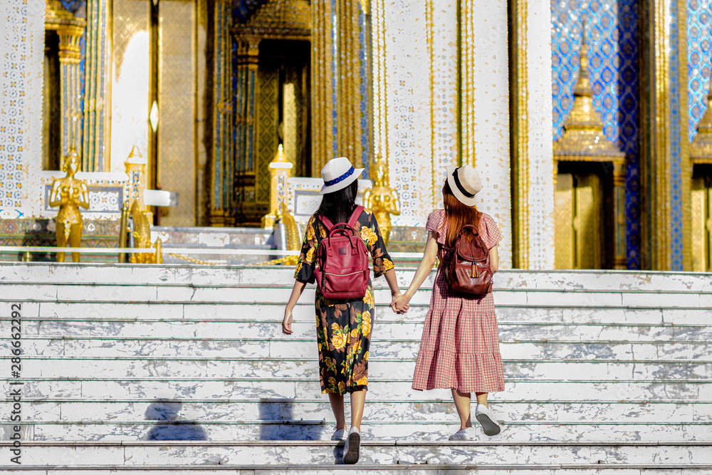 Naklejka premium young tourist woman walking through the palace temple in Bangkok of Thailand Emerald Buddha Temple, Wat Phra Kaew, Bangkok Royal Palace popular tourist place