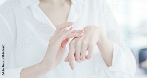 woman applying lotion on hand