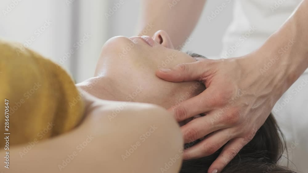 Spa facial massage. Face massage in beauty spa salon. Close-up of a woman's face. Young woman getting head massage Spa facial massage. Face massage in beauty spa salon. Close-up of a woman's face. Young woman getting head massage