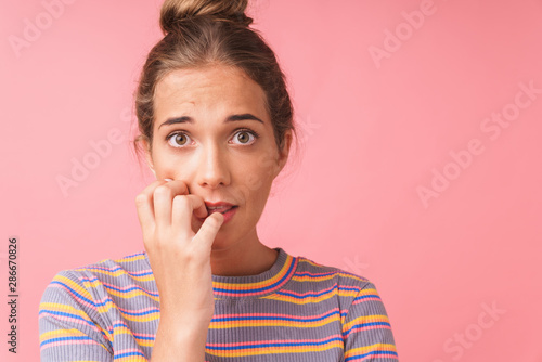 Quadro em tela Image closeup of scared young woman expressing wonder and biting her nails