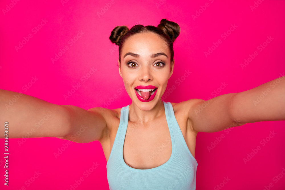 Pretty lady making selfies sticking tongue out of mouth wear casual outfit isolated pink background Pretty lady making selfies sticking tongue out of mouth wear casual outfit isolated pink background