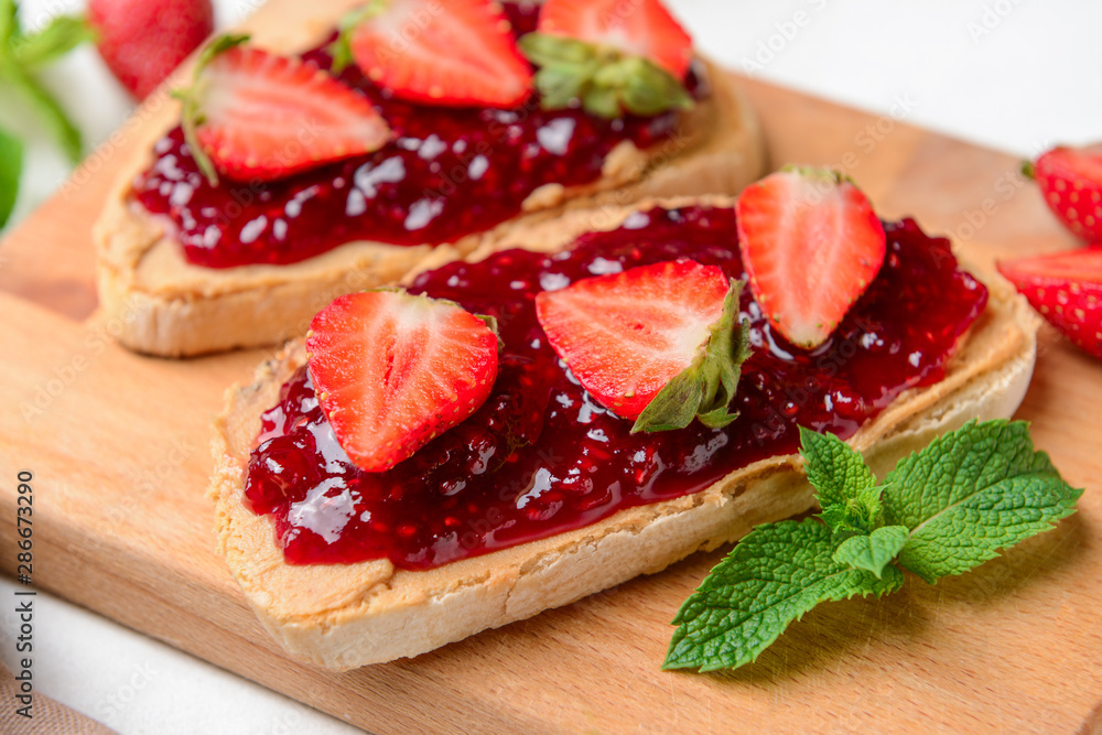 Toasted bread and strawberry jam on wooden board Toasted bread and strawberry jam on wooden board