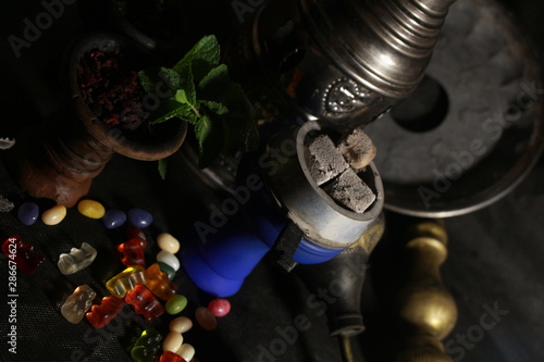 bowl with tobacco for hookah. berries on a black background
