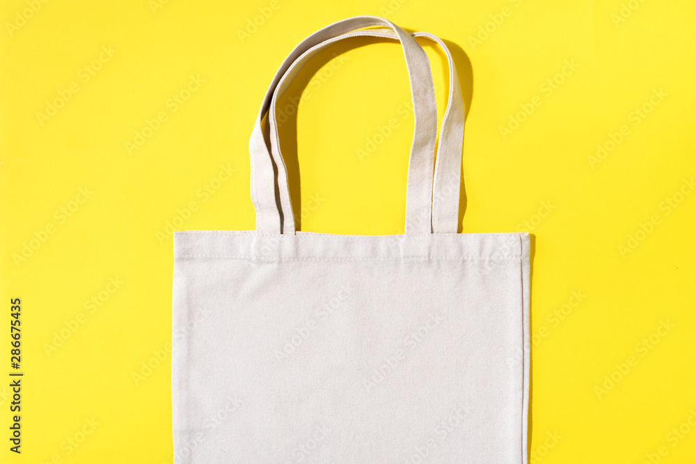 Reusable textile bag on yellow background. Zero waste concept with copy space. Zero waste, plastic free concept. Top view. Eco friendly mesh shopper.