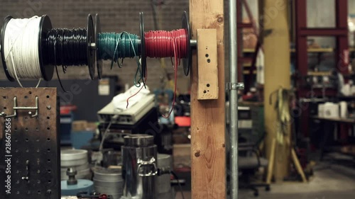 Sliding shot of wire spools on a worker's tool bench photo