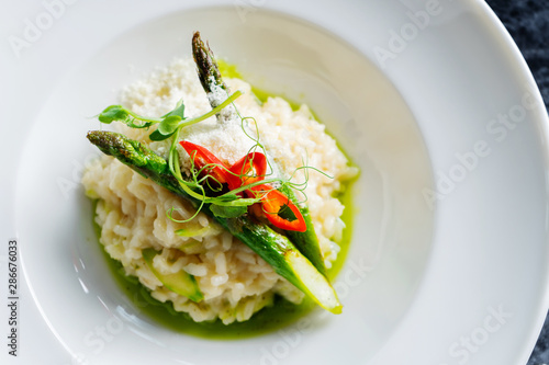 Close up view on tradtional and tasty risotto with parmesan, asparagus and chili. Mediterranean and italian cuisine. Soft, selective focus. Rise with asparagus. Copy space. Food photography
