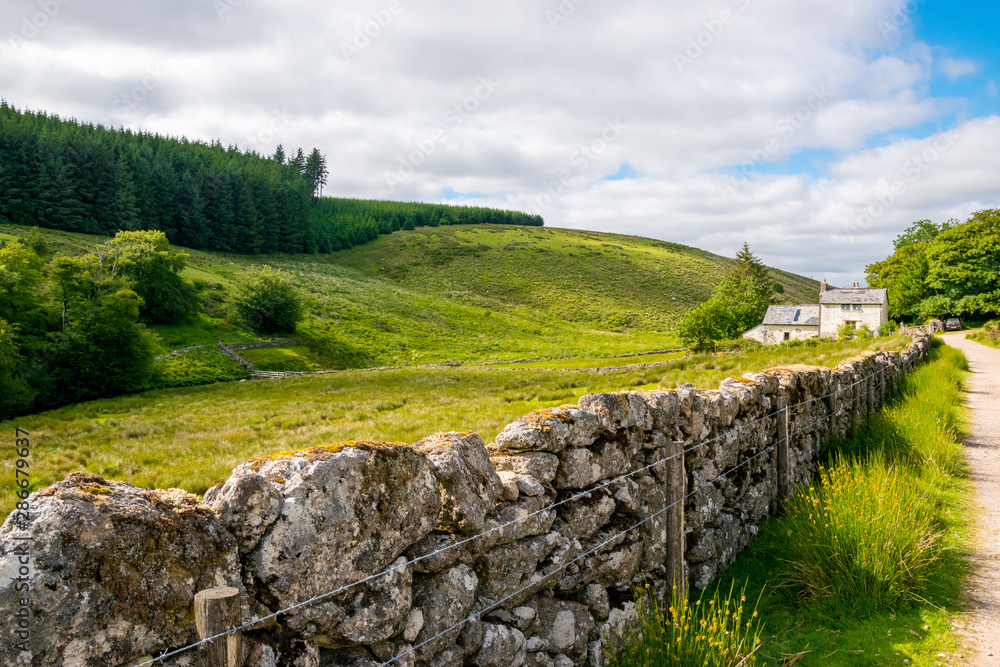 Scenic view of rural cottage and hillside landscape at Dartmoor National Park, Devon, England