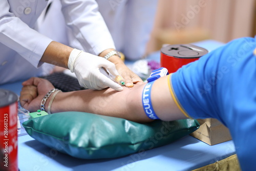 Thailand, Bangkok 2019/08/28. A health worker taking a blood sample from the vein by piercing the veinpunture and collecting blood into a test tube under negative pressure.