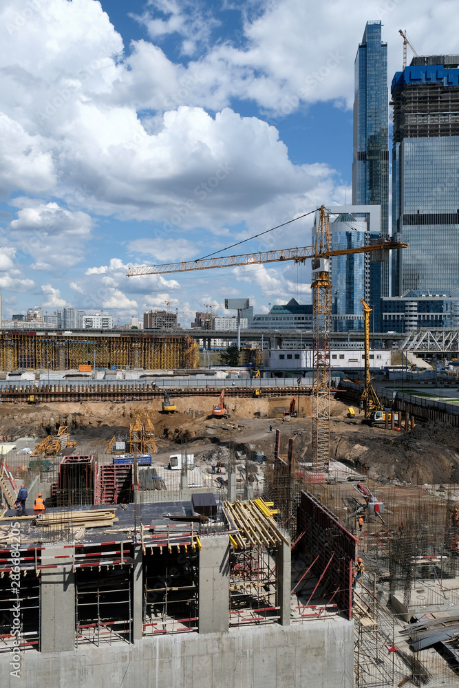 construction site with foundation pit in front of skyscraper, Moscow City, summer