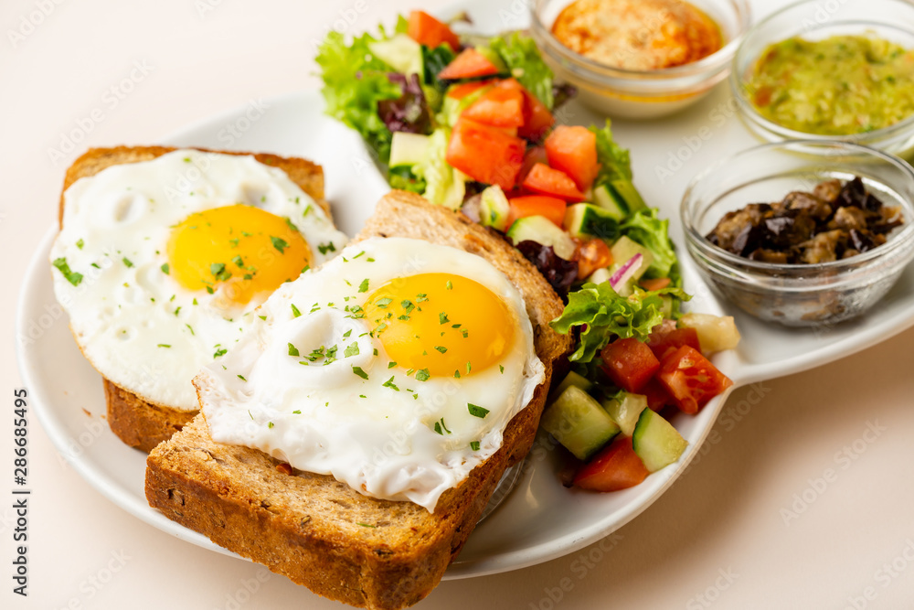 Fried eggs on toasted bread and salad Fried eggs on toasted bread and salad