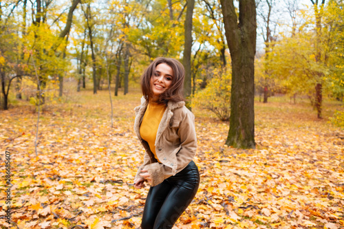 Happy Autumn. Beautiful Woman Fashion Model Having Fun in Fall Park Outdoors.young pretty woman in autumn park