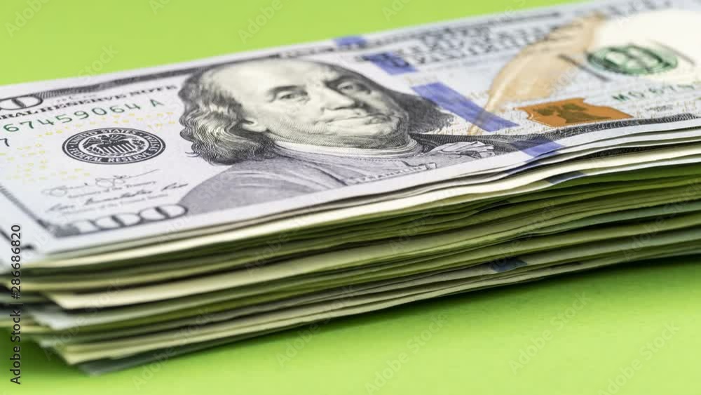 Spending money concept. Bundle of American dollars is decreasing one by one bill, becoming smaller and smaller. Stop motion animation. Spending money concept. Bundle of American dollars is decreasing one by one bill, becoming smaller and smaller. Stop motion animation.