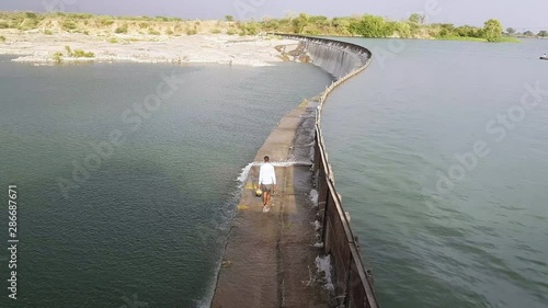 Wallpaper Mural Wide, man carrying bags crossing the Parichha Dam on the Betwa River in India Torontodigital.ca